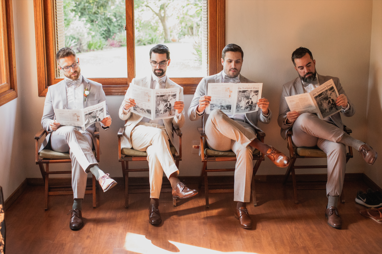 Padrinhos lendo o jornal dos noivos do Ateliê Espoir